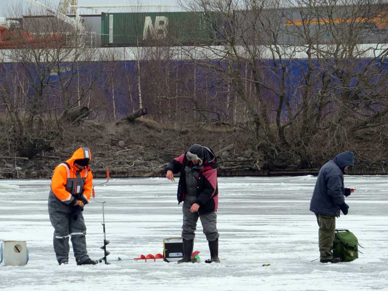 Three men drilling ice fishing holes, a closer picture