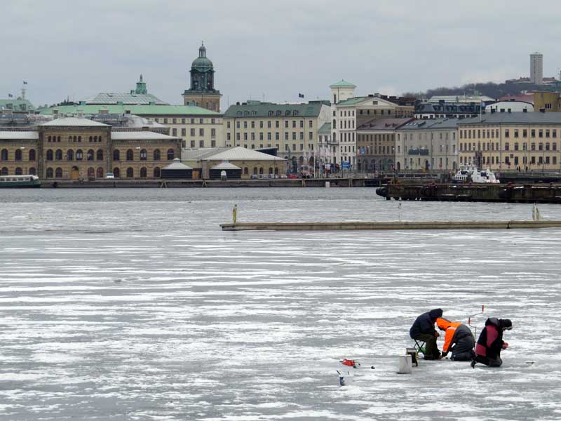 Three men drilling fishing holes in the ice of Sannegårdshamnen