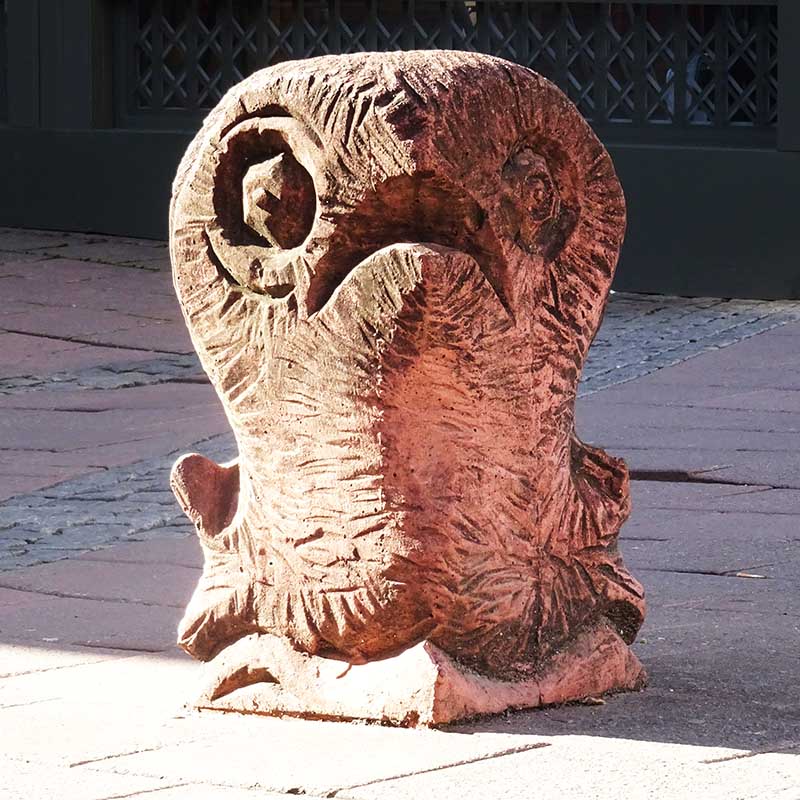 Apparently a bollard cut from wood, but probably cast concrete, depicting a baby bird with its mouth open hoping to be fed.