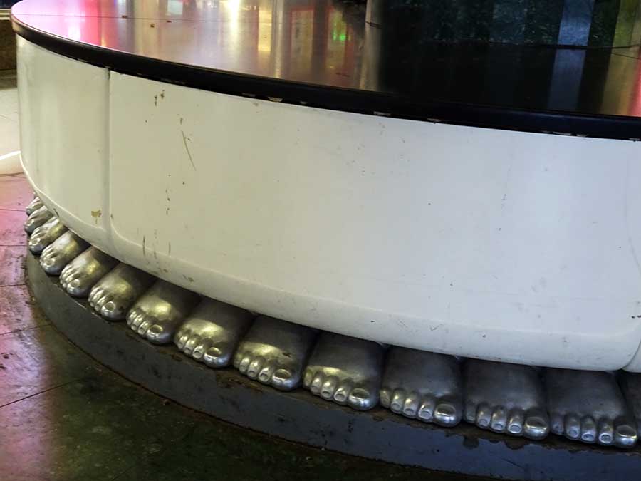 On the approach to the Östermalm underground station, a plinth that seems supported by dozens of silver right feet.