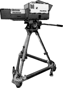 Photo-manipulated image of early TV camera standing on wheeled tripod.